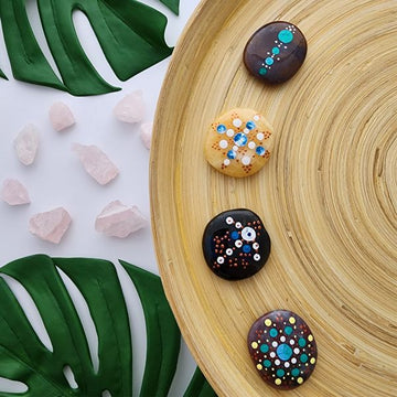 Shavasana Stones on wooden plate with green leaves as decoration